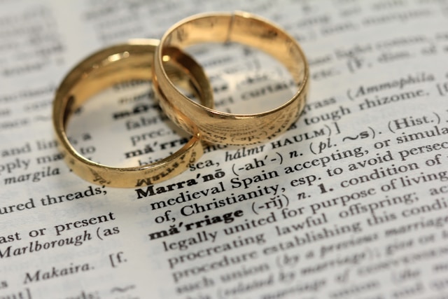 英語辞書で結婚という文字の上に金色の結婚指輪