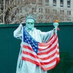 自由の女神がアメリカ国旗を持っている