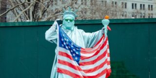 自由の女神がアメリカ国旗を持っている
